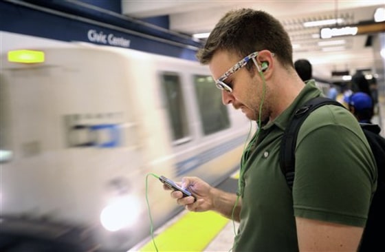 Nick Sabatasso checks his cellphone recently while waiting for a BART train at San Francisco's Civic Center station. Police say nearly one out of every three robberies in San Francisco this year has involved a cellphone.